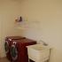 A red washer and drier under a white laundry shelf. | Houses for rent utilities included, Colorado Springs, CO
