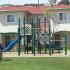 A children's playground with blue and green equipment. Behind the playground are white and red houses.| Military-Friendly Houses for rent Los Angeles, CA