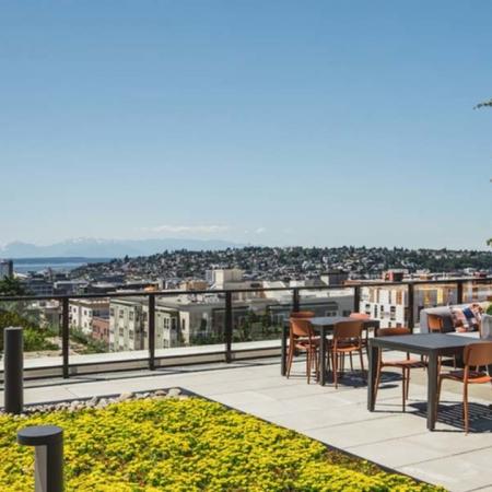 Rooftop dining area overlooking Seattle and mountain views at Modera Broadway apartments.
