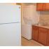 Kitchen with brown cabinets, washer and dryer, and brown cabinets at Chesapeake Village apartments for rent