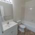 Model bathroom with vanity sink, toilet and tub shower at Oak Forest Apartments in Reading, PA.