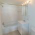 Bathroom with white tile and a vanity mirror at Gayley Park apartments for rent