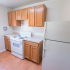 Kitchen with brown cabinets and white appliances at Evergreen Club apartments for rent in Broomall, PA