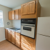 Wooden cabinets in a sunny kitchen with a window at Evergreen Club apartments for rent in Broomall, PA