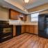 kitchen with hardwood floors and black appliances at Silver Springs Apartments in Springfield MO