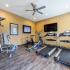 Fitness center with treadmill, tv, and weight machine