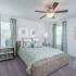 Artisan Living Bella Citta Rental Townhomes bedroom with two windows, carpet floor, and ceiling fan
