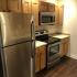Homeroom Lofts Apartments, interior, kitchen, woof floor, stainless steel appliances, refrigerator, stove/oven, microwave, tan cabinets