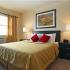 Master bedroom with queen bed and large window at The Commons at Fallsington apartments for rent in Morrisville, PA