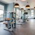 Fitness room with various cardio machines and weights.