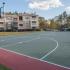 Full size basketball court with apartment buildings in background.