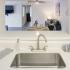 Modern, undermounted, single tub sink.  Opening above sink looks into living and dining areas.