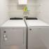 Side by side washer and dryer with two shelves above.