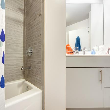 Spacious, large, luxury, modern bathroom with tile flooring, bath tub