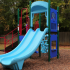 Outdoor Playground Structure: Double slide, climbers, playhouse, fenced.