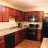 Black appliance package, Neutral colored counter-tops, wood-look laminate flooring, cherry cabinets.