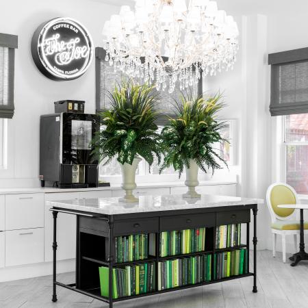 1810 The Social, interior, coffee book room, white, black, green, a sparkling chandelier, windows, table and chairs