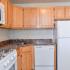 Brookstone Apts; Interior, kitchen, oak cabinets, marble countertops, white appliances, gas range, over head microwave with vent and light, dishwasher, frost free fridge, over cabinet storage, GFI outlets