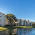 Creekside Park Apartments, exterior, river view, tan three level buildings, trees, grass