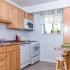 Clarke Manor Apts, Interior, Kitchen, maple cabinets, marble like counters, window in kitcehn, Breakfast bar with extra storage, bult-in microwave, gas range, dishwasher, frost free fridge, GFI outlets