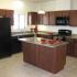 A kitchen with dark appliances and red-brown cabinets.  | Houses for rent utilities included, Alamogordo, NM
