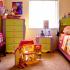 A young child's room filled pink, purple, yellow, and green furniture. A dollhouse sits in the middle of the floor between a dresser, night stand, and bed.. | Los Angeles, CA