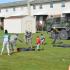 Several men in uniform playing games with children while a woman takes pictures. | Delta Junction Military Housing