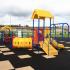 A children's playground with yellow, red, and blue equipment.