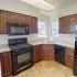 A State-of-the-Art Kitchen with black appliances and dark wood cabinets. | Apartments In San Pedro | Los Angeles AFB