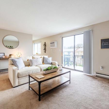 Living Room with sliding glass door opening onto a balcony | Princeton Reserve | Apartments Dracut MA