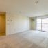 Large living area with carpet and sliding glass doors leading onto balcony  in apartment at at Westford Park apartments in Lowell, MA.