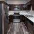 kitchen with stainless steel appliances, white countertops, dark cabinets and hardwood flooring at riverview trail apartments in whitefish Montana