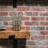 brick backsplash and exposed shelving in a studio apartment