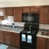 Newly remodeled kitchen with black appliances and dark brown cabinets