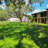 River View Apartments, exterior, large grassy area, trees, shade, benches, two level building, yellow,