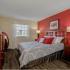 Belleza, interior, bedroom, wood floor, coral accent wall, window, large bed, dark dressers