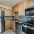 Gables at Honore model unit kitchen: stainless steel appliances, tiled back-splash, and wood cabinets