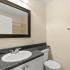 Beneva Place Apartments, interior, bathroom, whtie cabinets, dark counter, mirror, sink, toilet