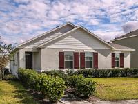 Exterior view with lush landscaping at a home for rent in Apopka, Florida.