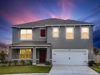 Photograph of the front side exterior of one of our homes in Apopka, FL, featuring a driveway, garage, and green lawn.