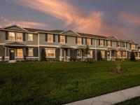 Exterior view of townhomes with lush landscaping during a beautiful sunset for rent in Apopka, Florida.