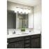 Double sinks in the bathroom with dark wood cabinets underneath. Long mirror that stretches across the counter top.