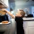 Boy standing in kitchen making his own toast.