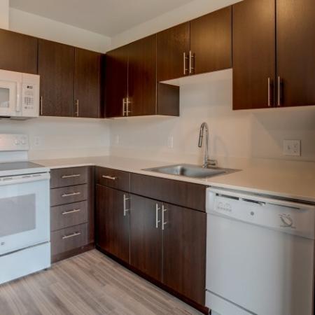 718 Kitchen with White Appliances & Dark Cabinetry | HANA Apartments | Seattle Studio Apartments