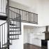 View of loft floorplan with metal spiral staircase and kitchen with white refrigerator, white dishwasher, and stainless steel oven