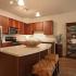 Kitchen with granite counters, stainless steel appliances, and brown cabinets.