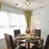 Dining area with lots of windows furnished with a circular table and 4 chairs at Spring House Apartments in Laurel, MD.