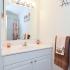 White bathroom sink and vanity with large mirror and towel bar