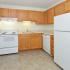 Kitchen with white appliances and wood cabinets at Boothwyn Court apartments for rent