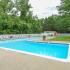Community swimming pool with lounge chairs and umbrellas at Whiteland West Apartments in Exton, PA.